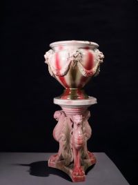 Imposant cache pot sur colonne en barbotine à décor de griffons et de têtes de lions, vers 1900.