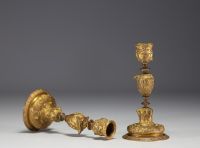 A pair of 19th century gilt bronze candlesticks, decorated with antique figures and goat heads.