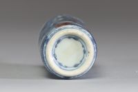 Chine - Tabatière en porcelaine blanc bleu et rouge fer à décor de dignitaires, bouchon en corail.
