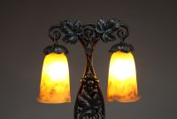 MULLER Frères Lunéville - Lampe de table Art Nouveau à double éclairage, montures en fer forgé à décor de vigne, verre marmoréen orangé, signée Muller Frès Lunéville.