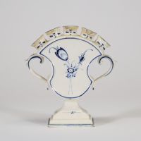 Boch  Luxembourg, fin XVIIIe – début XIXe siècle. Charmant porte-bouquet en faïence fine à panse galbée, orné d’un décor  bleu sous couverte, dit « à la brindille » ou « décor bleu de Luxembourg ».