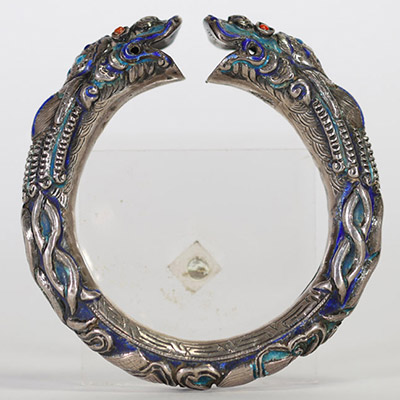 Chine, bracelet rigide en argent et émaux polychromes à décor de dragons affrontés, XIXe siècle Bracelet ouvrant finement ciselé en argent, à décor en fort relief de deux dragons stylisés se faisant f