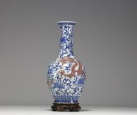 China - A white-blue porcelain vase decorated with a dragon and an iron-red phoenix, mark under the piece, 18th century.