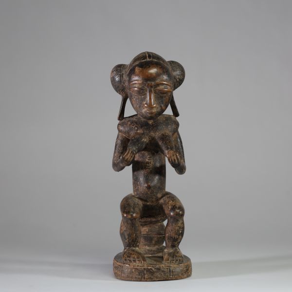 Statue féminine Baoulé, Côte d’Ivoire. Bois, patine ancienne usée par l’usage rituel. H : 30 cm Ancienne collection privée Liège