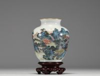 Chine - Vase en porcelaine polychrome à décor de paysage, socle en bois, marque au bleu sous la pièce.