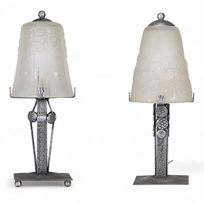 Muller Frères, Lunéville, vers 1930 Ensemble de deux lampes Art Déco en verre moulé-pressé et monture en métal ouvragé à finition nickelée mate.  Chacune des lampes repose sur une base rectangulaire en métal travaillé au repoussé, présentant une surface texturée de motifs géométriques martelés typiques de la période Art Déco. Le fût vertical, orné de pastilles et de stries régulières, soutient une