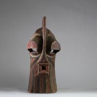 Grand masque Songye Kifwebe « Kilume ». Rd Congo. Bois. De forme allongée, une crête sagittale proéminente, une bouche saillante percée, et surtout des yeux fortement protubérants. Les stries rituelles incisées en spirale alternent des pigments bruns, noirs et ocre clair. Ce type de masque est conçu pour impressionner et symboliser les forces occultes ou sociales. La patine extérieure est mate, pr