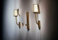 Jean PASCAUD (1903-1996)  Ensemble composé d'une applique double et d'une paire d'appliques simples en bronze doré patiné.