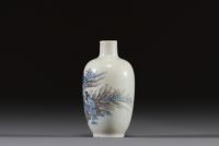 Chine - Tabatière en porcelaine polychrome bleu, grisaille et rouge de fer à décor d'un paysage animé, dynastie Qing, marque sous la pièce.