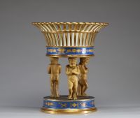 Milieu de table en porcelaine blanche, bleue et or, corbeille ajourée supportée par trois amours, Empire.