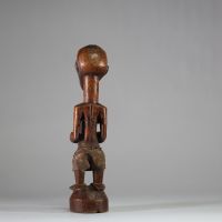 Fétiche rituel figurant un nkishi protecteur ethnie Songye, sous groupe Kalebwe. Figure dotée d'un long cou, de pieds larges, d'un visage souriant et d'une ceinture abdominale contenant une charge organique et présentant autrefois une corne magique au sommet du crâne. Usure rituelle et patine ancienne authentifient son usage. Très belle représentation Kalebwe, entre force symbolique et expressivit