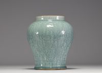 China - Pale green monochrome porcelain vase with floral decoration in relief, blue mark under the piece, 17th century.