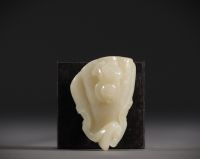 Chine - Pendentif en Jade blanc sculpté en forme de fruit surmonté d'un jeune enfant.