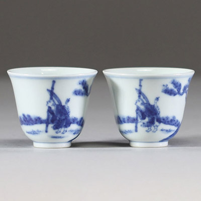 Chine – Paire de petites coupes en porcelaine blanc bleu à décor de lettrés à cheval sous les pins, marque apocryphe de Kangxi  Paire de coupes évasées en porcelaine à décor en bleu sous couv