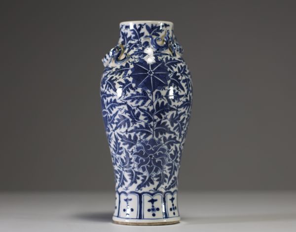 China - A white-blue porcelain vase decorated with flowers and foliage, chilong in relief on the shoulder, 19th century.
