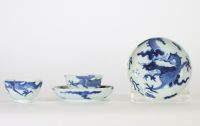 Chine, dynastie Qing – Ensemble de quatre bols et soucoupes en porcelaine bleu et blanc à décor de dragons parmi les nuées