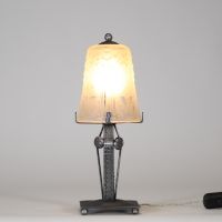 Muller Frères, Lunéville, vers 1930 Ensemble de deux lampes Art Déco en verre moulé-pressé et monture en métal ouvragé à finition nickelée mate.  Chacune des lampes repose sur une base rectangulaire en métal travaillé au repoussé, présentant une surface texturée de motifs géométriques martelés typiques de la période Art Déco. Le fût vertical, orné de pastilles et de stries régulières, soutient une