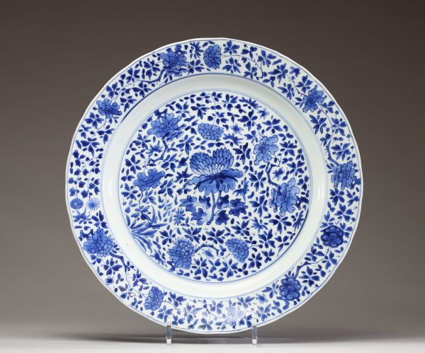 Chine – Plat en porcelaine blanc bleu à décor de fleurs de Lotus, marque d’atelier sous la pièce  Plat en porcelaine à décor bleu sous couverte de fleurs de lotus sur l’aile et au centre, le revers or
