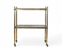 Desserte à deux plateaux attribuée à la Maison Jansen, vers 1940 Élégante desserte en métal doré à deux plateaux en miroir au mercure vieilli, montée sur roulettes. L’ensemble présente une structure à colonnettes cannelées surmontées de prises en toupie, typique des productions de la Maison Jansen dans les années 1940. Un meuble raffiné aux proportions équilibrées, mêlant fonctionnalité et style n