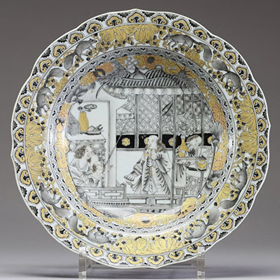 Chine – Assiette en porcelaine de la Compagnie des Indes à décor peint en grisaille et or d’une scène de famille, XVIIIe siècle. Charmante assiette à bord chantourné en porcelaine, décorée en grisaill