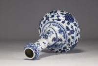 China - A white-blue porcelain vase decorated with a chimera in relief winding around the neck and floral motifs, 18th century.
