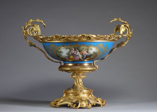 Sèvres - Grande coupe en porcelaine à décor floral peint, dorures et scène galante sur fond bleu céleste, monture bronze doré, XIXème.