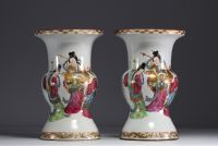 China - A pair of famille rose porcelain vases decorated with dignitaries, courtesans and poems, 19th century.