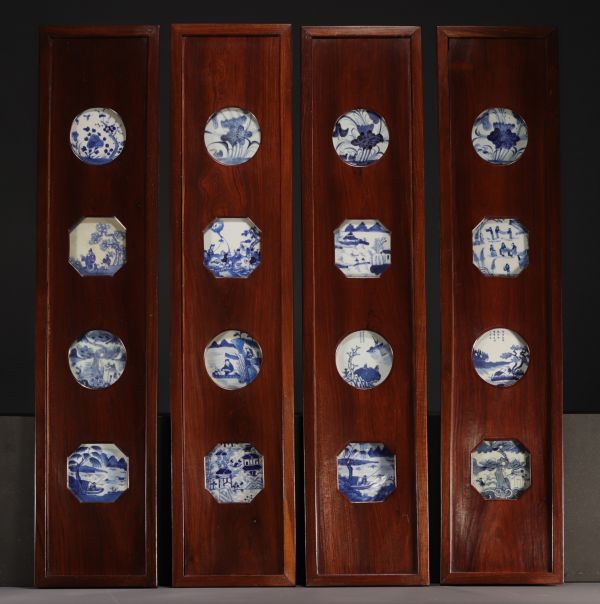 Chine - Suite de quatre panneaux ornés de seize porcelaines blanc bleu, époque Ming et Kangxi, XVIIIème.