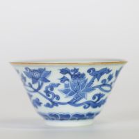 Chine, bol en porcelaine blanc-bleu à décor de fleurs de lotus épanouies et en bouton surmontant une frise de vagues, l'intérieur orné d'une fleur stylisée et la base portant une marque apocryphe à si
