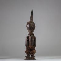 Fétiche Songye Nkisi, sous style Kalebwe, RD Congo. H : 46 cm. Figure masculine en bois, surmonté d’une corne rituelle, visage orné de clous de tapissier à fonction magique. Patine ancienne noire /brune, accessoires rituels suspendus (perles, fibres, cordelettes), cavités sous les bras. Nkisi de protection ou de justice activé par un « Nganga ». Style expressif et puissant propre aux Songye Kalebw