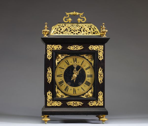 Pendule religieuse en bois noirci et ornements floraux en bronze doré, cadran anneau en laiton. 