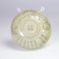 Bol en jade céladon finement gravé d’un paysage montagneux et d’un poème calligraphié, marqué Qianlong  Bol circulaire en jade de teinte céladon très pâle, finement incisé d’un décor continu représent