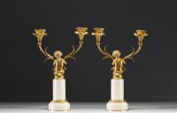 A pair of ormolu candelabra with cherubs and two arms, alabaster base, Napoleon III period.