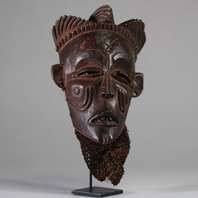 Ancien masque tribal avec coiffe « Mwana pwo » Chokwe/ Tshokwe, RD Congo, Angola. Bois, raphia. Le visage est de forme légèrement allongée, avec un front large et bombé qui s'effile vers un menton délicat. Les proportions sont harmonieuses, créant une impression de calme et de sérénité. Nez fin et droit. Nombreuses scarifications dont « cingelyengelye » sur le front, l’emblème royal. Très belle pa