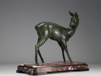 Grande sculpture d'une biche en régule à patine verte sur socle en marbre rose et noir, non signée.
