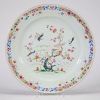 Assiette en porcelaine de Chine, famille rose, à décor d’oiseaux dans un paysage fleuri, XVIIIe siècle