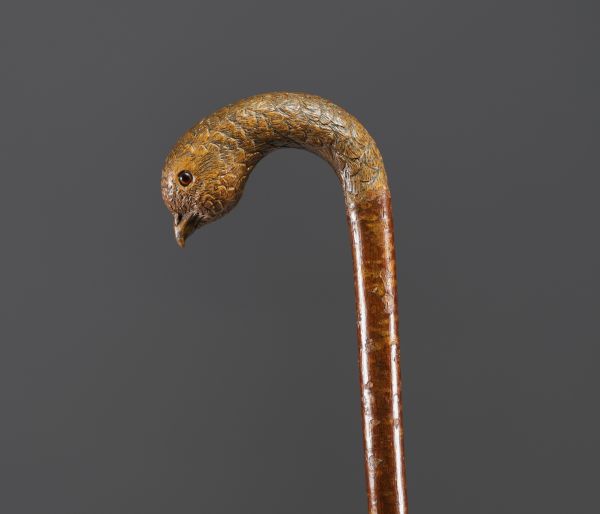 Carved wooden cane with bird's head motif, glass eyes.