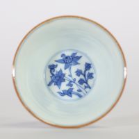 Chine, bol en porcelaine blanc-bleu à décor de fleurs de lotus épanouies et en bouton surmontant une frise de vagues, l'intérieur orné d'une fleur stylisée et la base portant une marque apocryphe à si