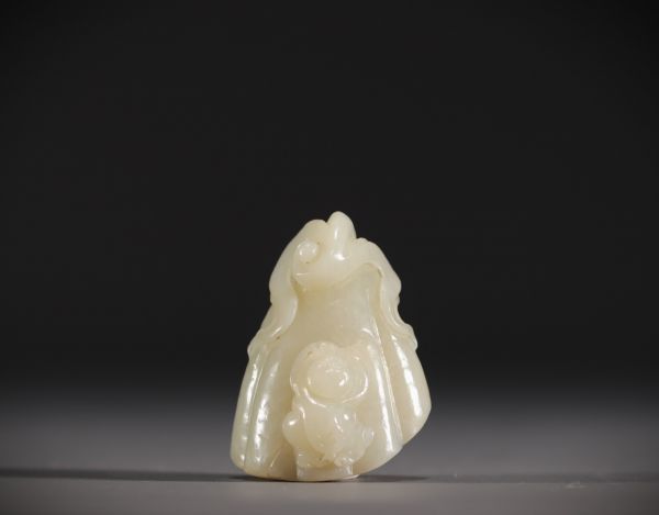Chine - Pendentif en Jade blanc sculpté en forme de fruit surmonté d'un jeune enfant.
