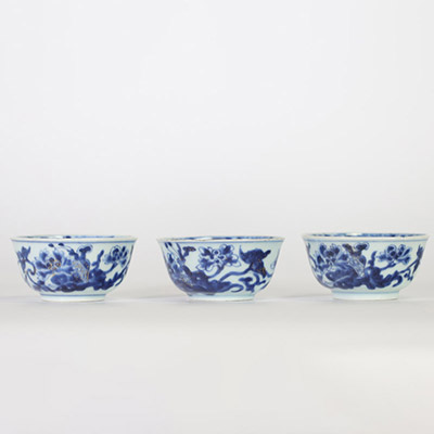 Chine, trois bols en porcelaine bleu et blanc, dynastie Qing, XVIIIe siècle, décorés de fleurs et symboles bouddhiques en léger relief au bleu sous couverte, l’intérieur orné d’une fleurette stylisée.