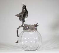 Valenti, Espagne, vers 1960 Aiguière en verre soufflé et monture en métal argenté à décor de sanglier.  Remarquable aiguière à panse godronnée en verre transparent, coiffée d’un couvercle sculptural en métal argenté figurant avec réalisme une tête de sanglier, gueule entrouverte et oreilles dressées.