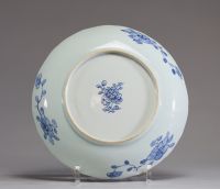 Chine - Assiette festonnée en porcelaine blanc bleu à décor de personnages, motif floral sous la pièce.
