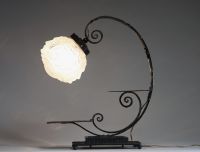 André HUNEBELLE (1896-1985) dans le goût de - Lampe pied fumer en fer forgé martelé et globe en verre moulé pressé à décor de visages de femmes, vers 1920-30.