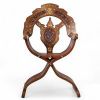 Fauteuil pliant syrien en bois incrusté de cuivre et signé, début du XXe siècle Structure en bois sculpté, incrustations de filets de cuivre et de laiton à décor floral stylisé
