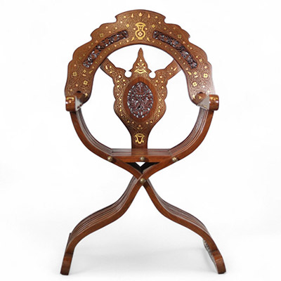 Fauteuil pliant syrien en bois incrusté de cuivre et signé, début du XXe siècle Structure en bois sculpté, incrustations de filets de cuivre et de laiton à décor floral stylisé
