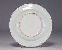 China - A polychrome porcelain plate, decorated with figures, animals and flowers, early 18th century.