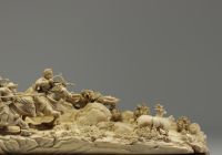 China - Ivory group carved in a tusk, depicting a hunt, silver-veined wooden base, circa 1920-30