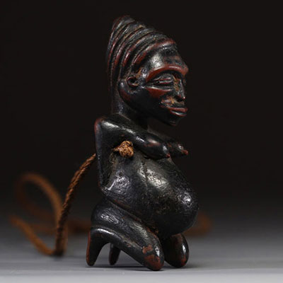 Afrique - Gabon - Amulette Lumbo en bois sculpté représentant une maternité, collier en raphia, première moitié XXème.