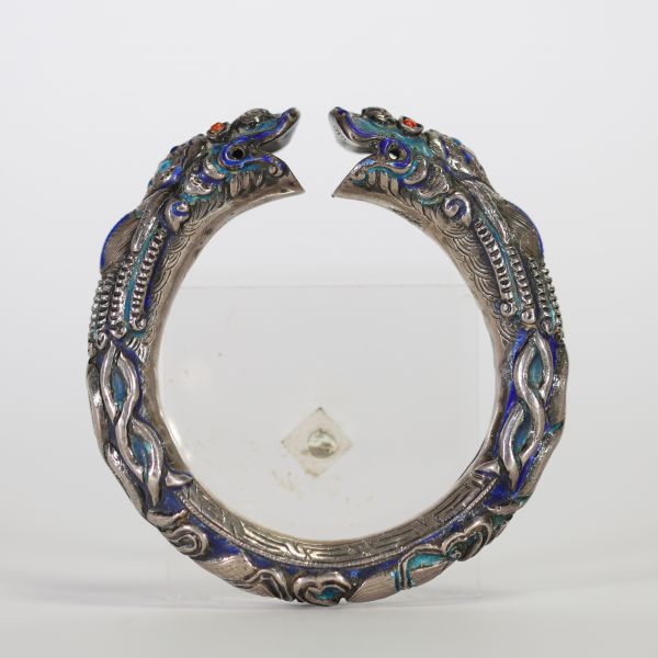 Chine, bracelet rigide en argent et émaux polychromes à décor de dragons affrontés, XIXe siècle Bracelet ouvrant finement ciselé en argent, à décor en fort relief de deux dragons stylisés se faisant f