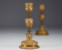 A pair of 19th century gilt bronze candlesticks, decorated with antique figures and goat heads.